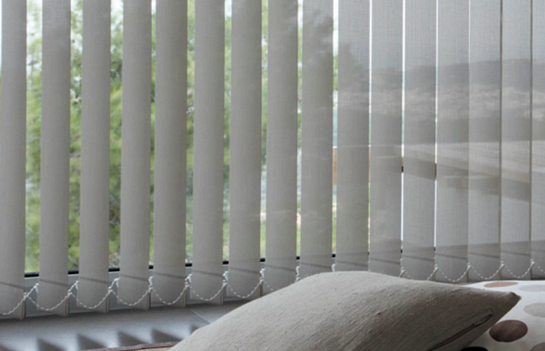 Cortinas verticales Bandalux en salón con ventanal